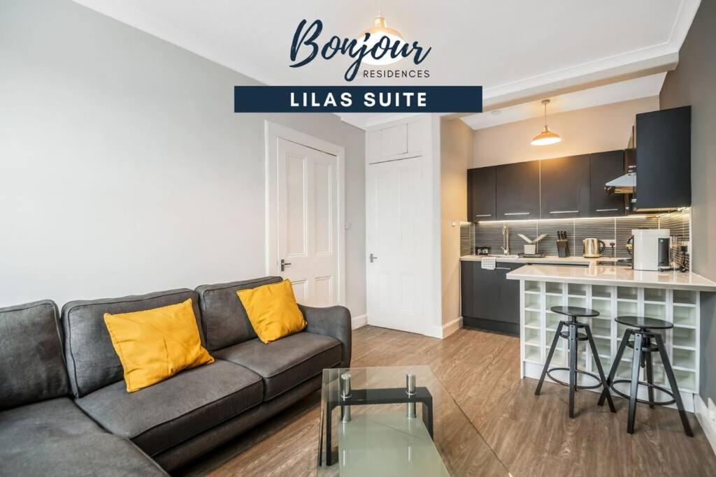 a living room with a couch and a kitchen at Lilas Suite Abbeyhill - 1BR-1BA 5 Mins to Meadowbank Shopping by Bonjour Residences Edinburgh in Edinburgh