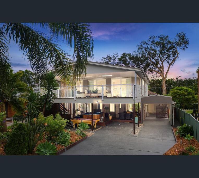 a large house with a lot of windows at Lake-view Retreat w Spa, nearby Beaches & Shopping in the Central Coast in Lakeside
