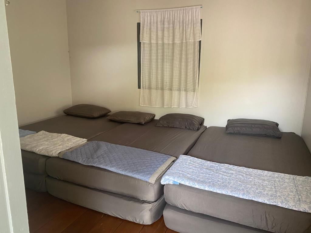 two beds in a room with a window at Mango tree cafe de’ villa in Mae Pim