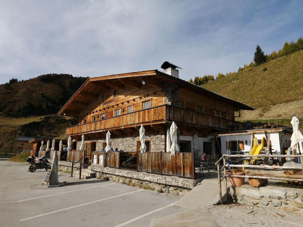 a large wooden building in a parking lot at unique large alpine pasture in the middle of the Zillertal mountains in Zellberg