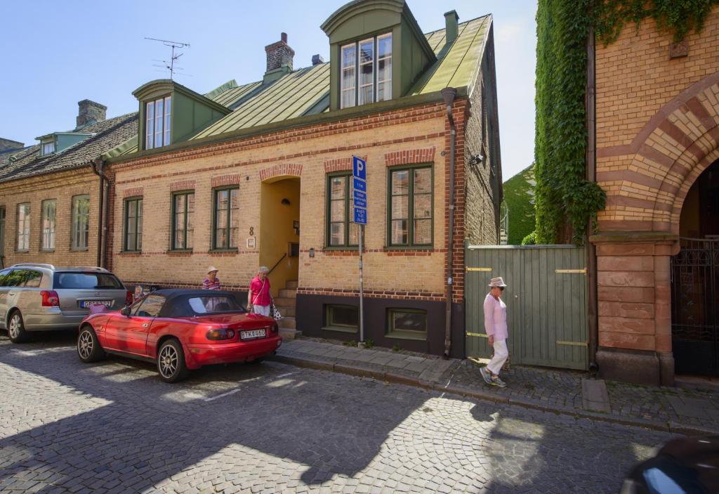 un'auto rossa parcheggiata di fronte a un edificio di mattoni di Magles Smiley Inn a Lund