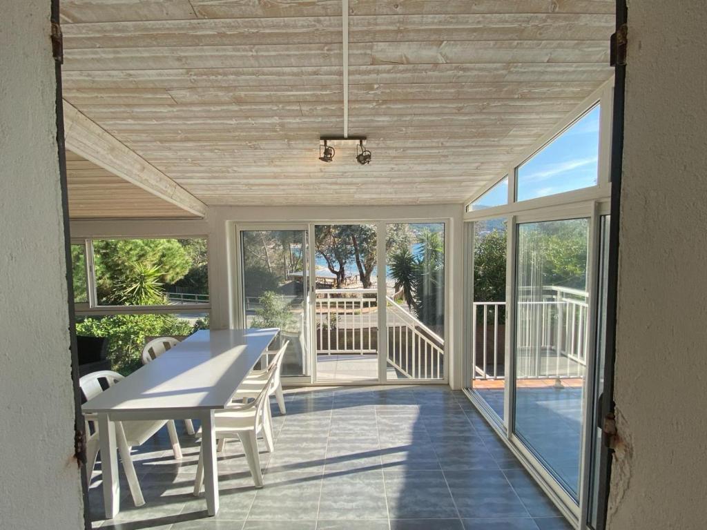 une véranda avec une table et des chaises dans l'établissement Appartement t3 à 50m de la plage Haut, à Pietrosella