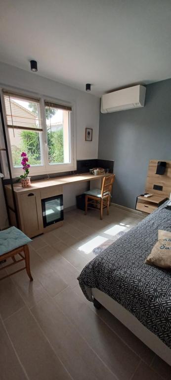 ein Schlafzimmer mit einem Bett, einem Schreibtisch und einem Stuhl in der Unterkunft Chambre climatisée indépendante 300m mer in Six-Fours-les-Plages