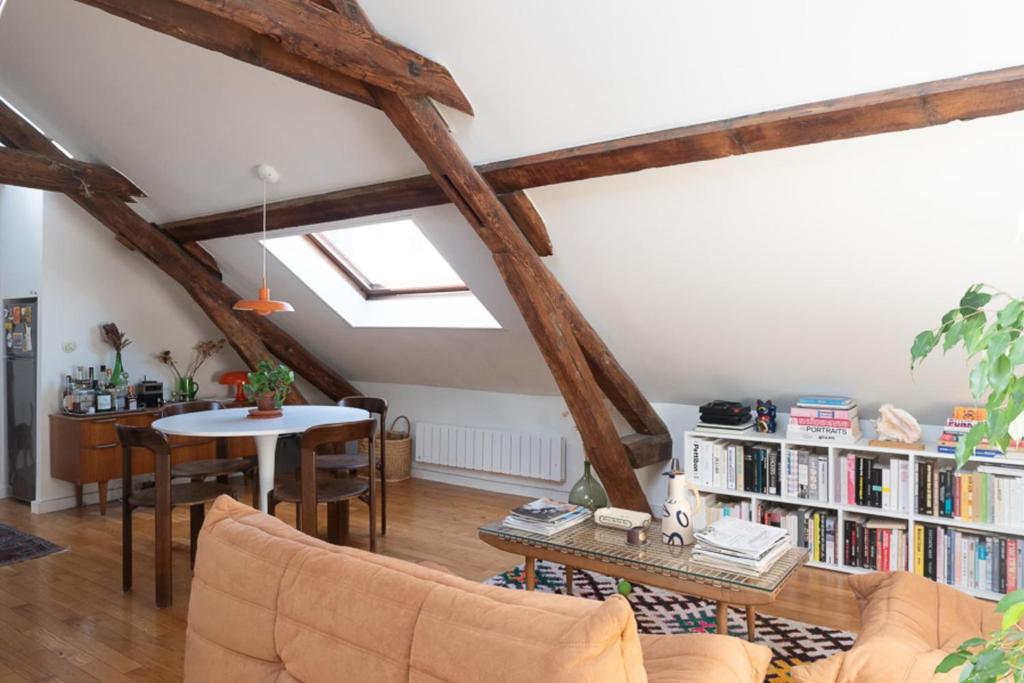 a living room with a book shelf and a table at Cozy 55 m close to the Seine in Saint-Denis