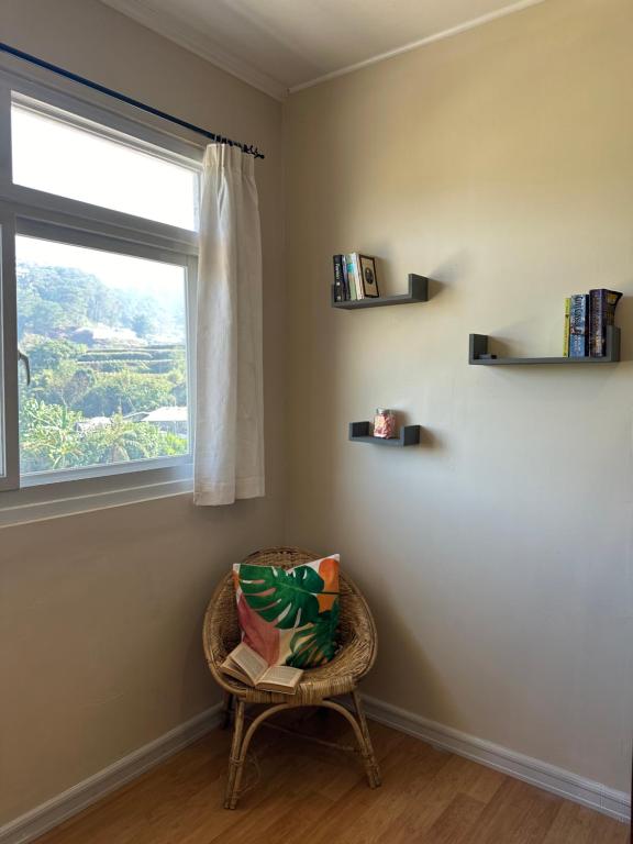 a chair sitting in a room with a window at Riverside 2bed cozy apartment in La Trinidad
