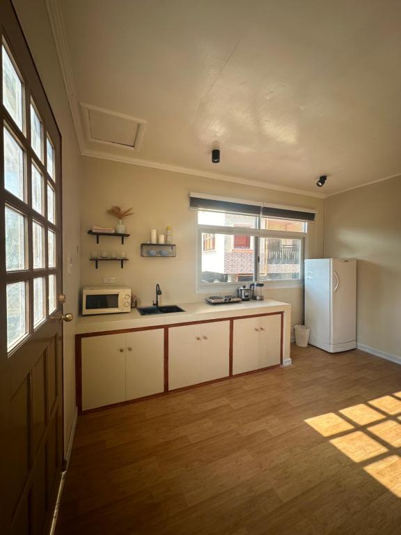 a kitchen with white cabinets and a refrigerator at Riverside 2bed cozy apartment in La Trinidad
