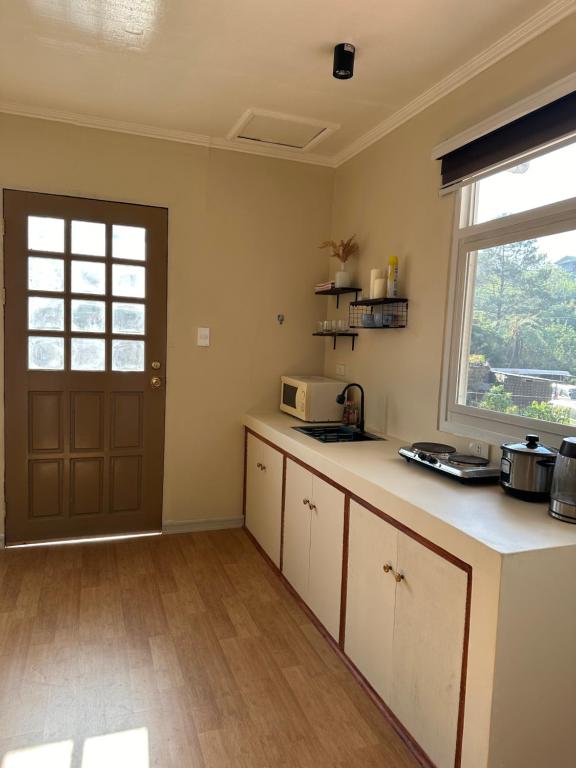 a kitchen with a counter with a microwave and a window at Riverside 2bed cozy apartment in La Trinidad