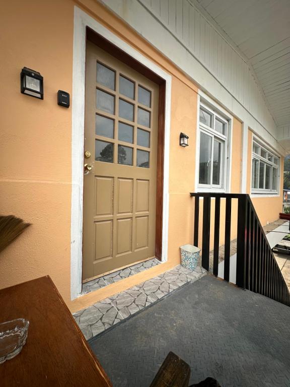 a front door of a house with a porch at Riverside 2bed cozy apartment in La Trinidad
