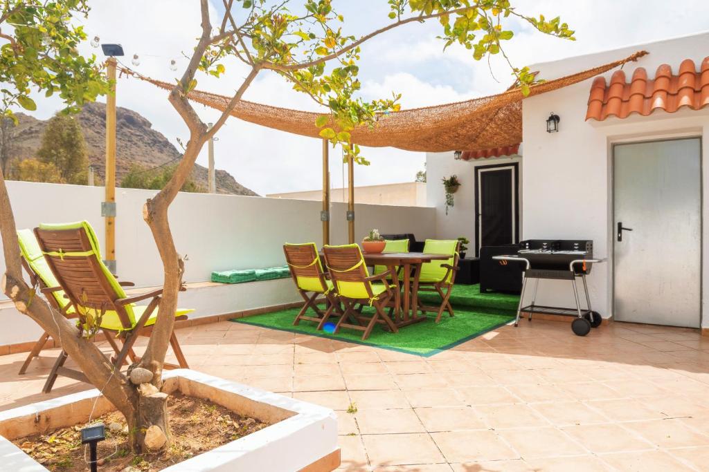 a patio with a table and chairs and a tree at Casa El Limonero in Níjar
