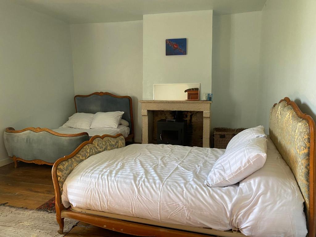 sypialnia z 2 łóżkami i kominkiem w obiekcie Pear Tree B & B w mieście Montembœuf