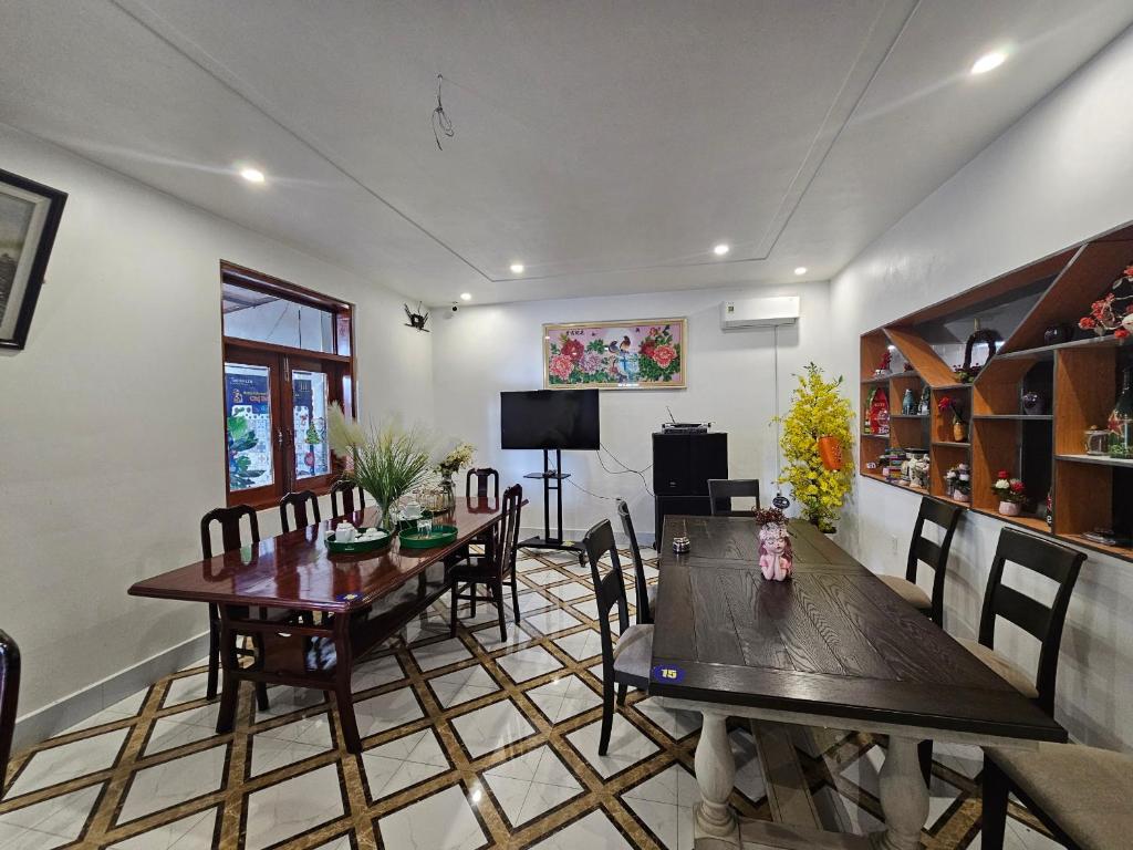 - une salle à manger avec deux tables et des chaises en bois dans l'établissement Sunny 1 Hometel Vinh Long, à Vĩnh Long