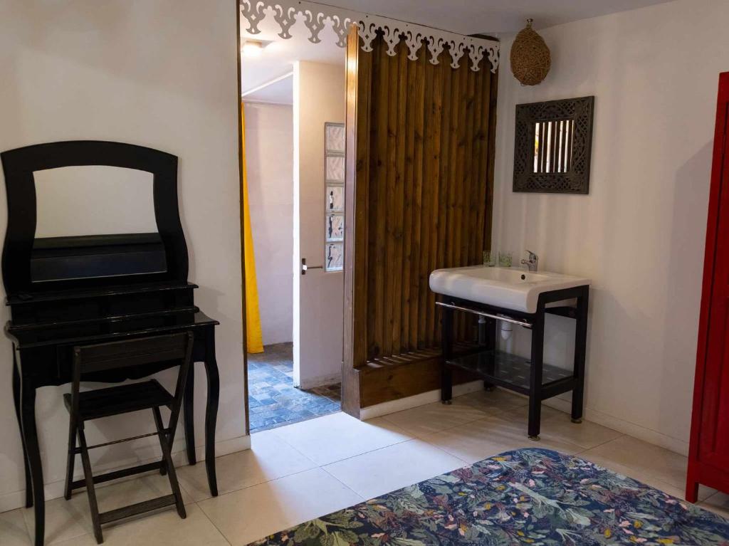 勒唐蓬的住宿－Freedomhome974，一间带水槽、镜子和钢琴的浴室