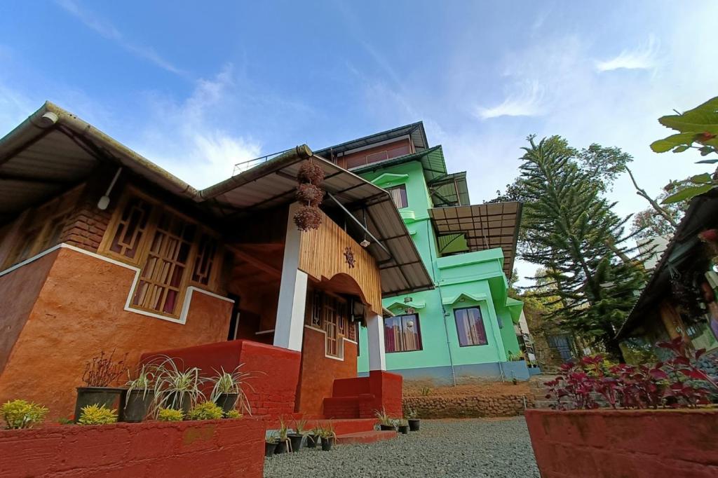 a house that is painted green and orange at Exotica Holidays in Viripara
