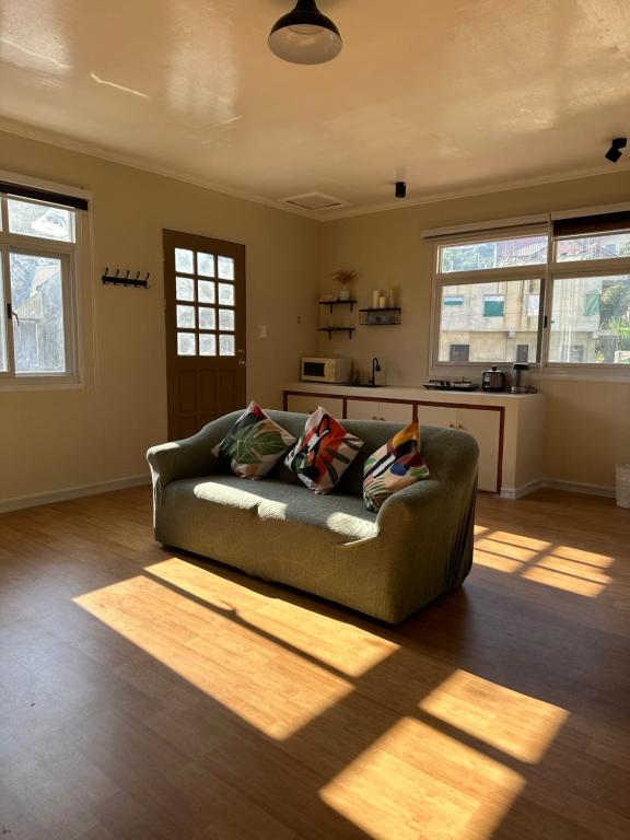 a living room with a couch and a kitchen at Riverside 2bed cozy apartment in La Trinidad