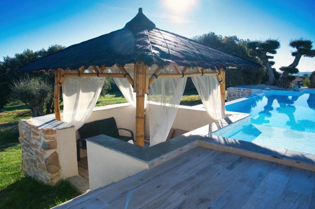 - un kiosque en bois à côté de la piscine dans l'établissement Maison, à Bourg-Saint-Andéol