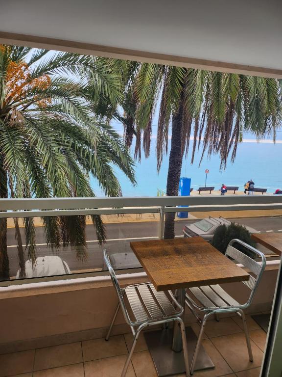 une table et des chaises sur un balcon avec vue sur la plage dans l'établissement Bluemarine, studio vista Mare, à Menton