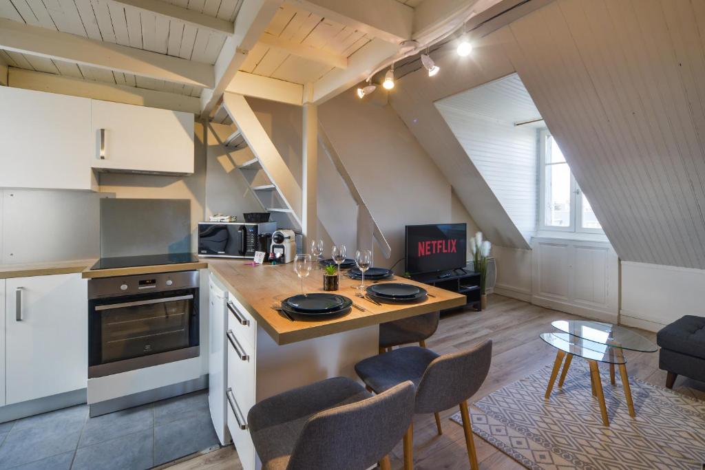 une cuisine avec une table et des chaises dans une pièce dans l'établissement Le Saint-Martin - Hypercentre - Netflix, à Tours