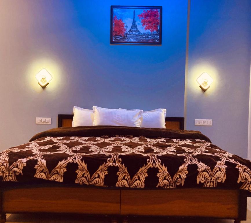 a bedroom with a bed with two lights on the wall at Snow Crest Residency Manali in Manāli