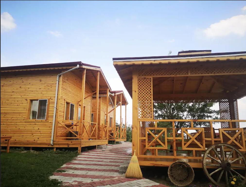 a wooden cabin with a wagon parked in front of it at Şahan Bungalov in Gökçe