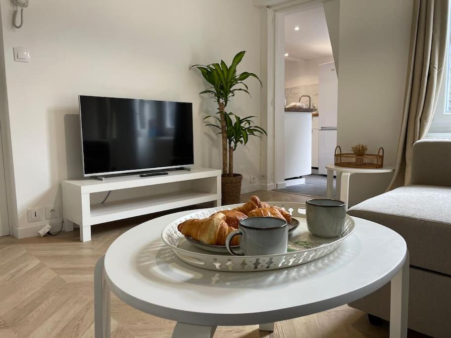 a living room with a coffee table with a plate of food at Le logis du Gros Horloge - Cosy et Douillet in Rouen