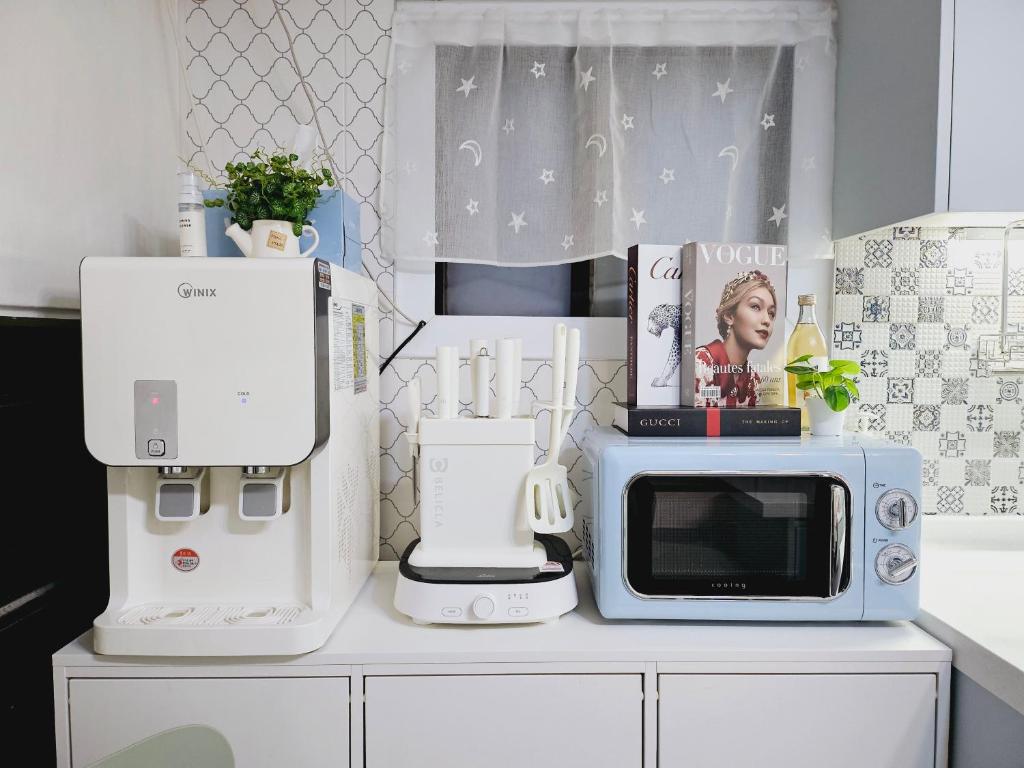 a kitchen counter with a microwave and appliances on it at K Highstel Uijeongbu 35 in Uijeongbu