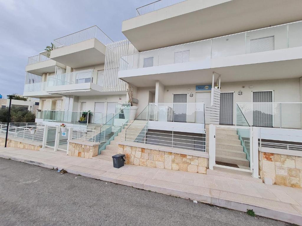 an apartment building with stairs and a balcony at Dimora Kalypso in Polignano a Mare