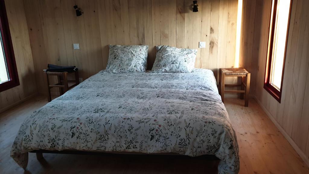 - une chambre avec un lit avec une couette blanche et 2 fenêtres dans l'établissement L 'Echo des bois, à Ambillou-Château