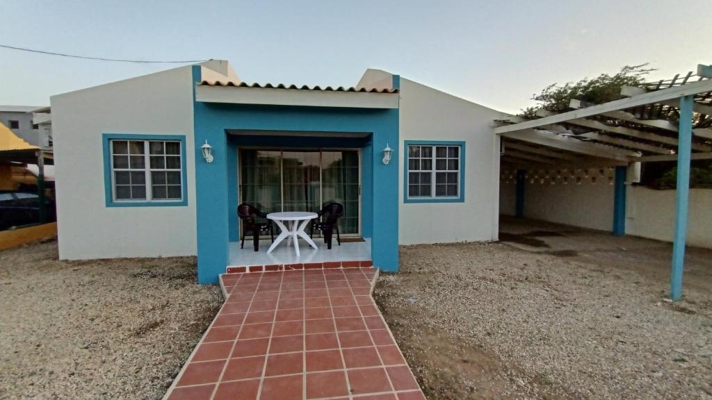 a small blue and white house with a table at villa nikiboko Bonaire in Kralendijk