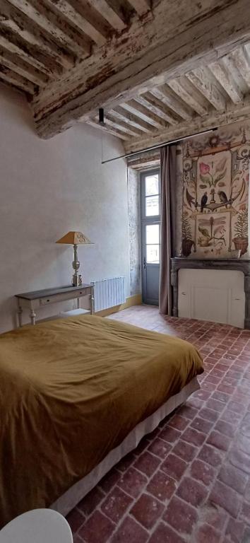 a bedroom with a large bed in a building at Logis La Vachère in Avallon