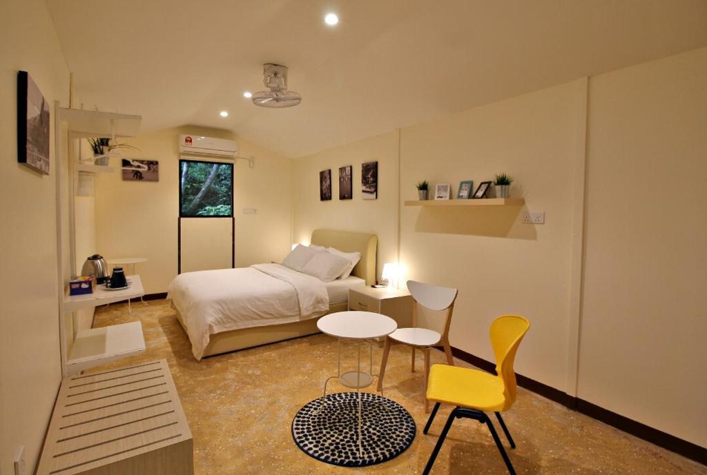 1 dormitorio con 1 cama, mesa y sillas en Xscape Tambun, en Ipoh