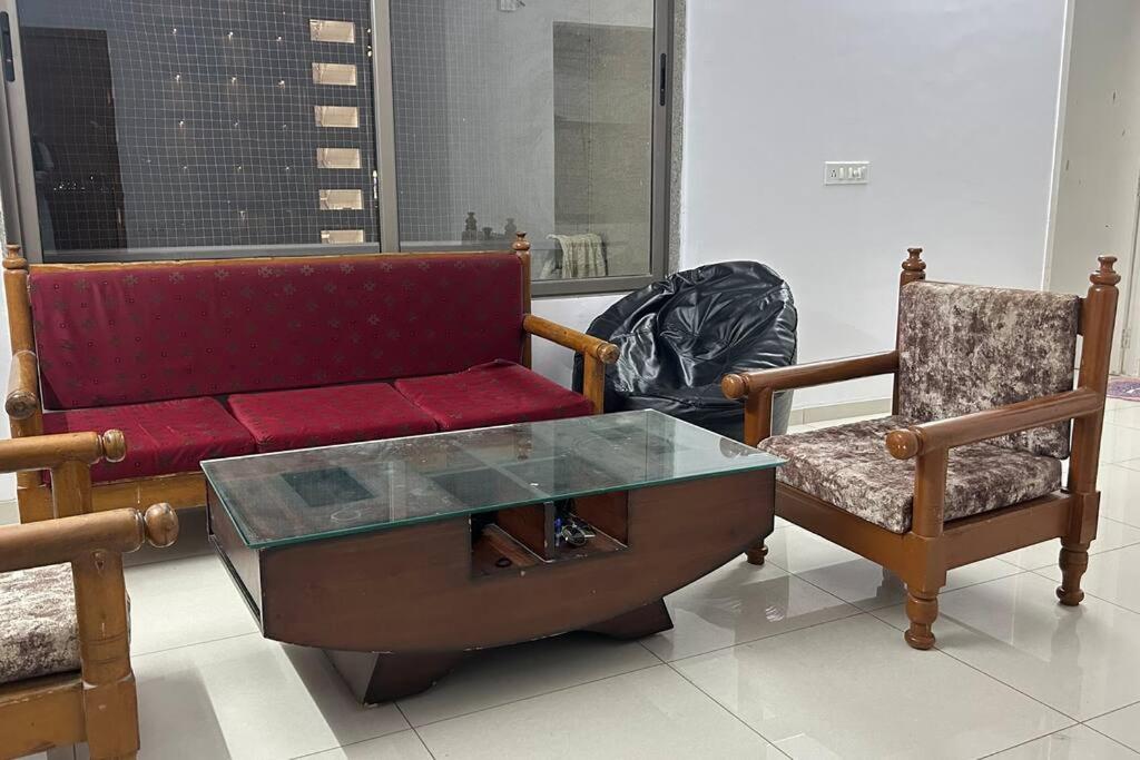 sala de estar con sofá y silla en Saral Sky Near Agora Mall, en Ahmedabad
