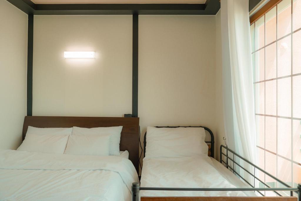 Postel nebo postele na pokoji v ubytování ttottot Jeju Backpackers