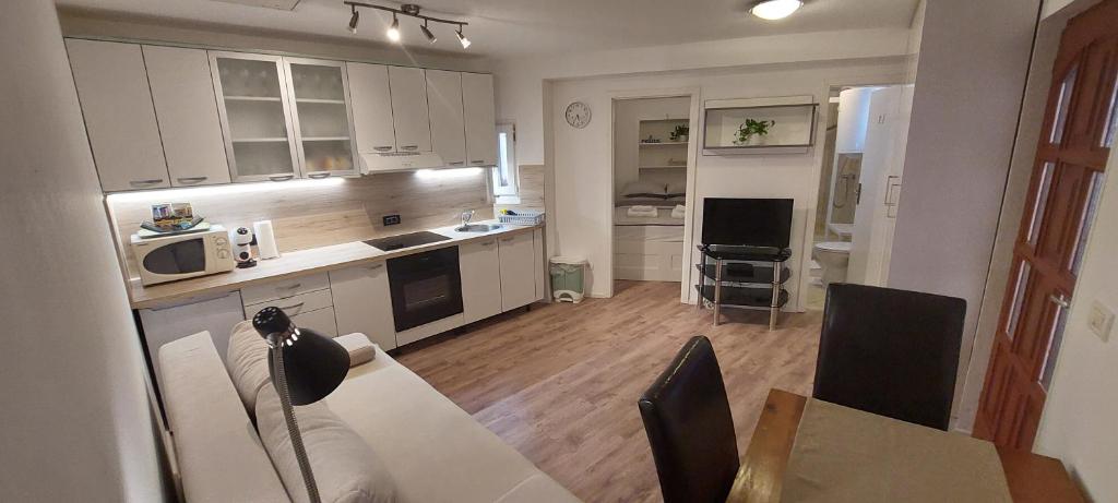 una cocina con armarios blancos y una mesa con comedor. en Apartment Kremen en Izola