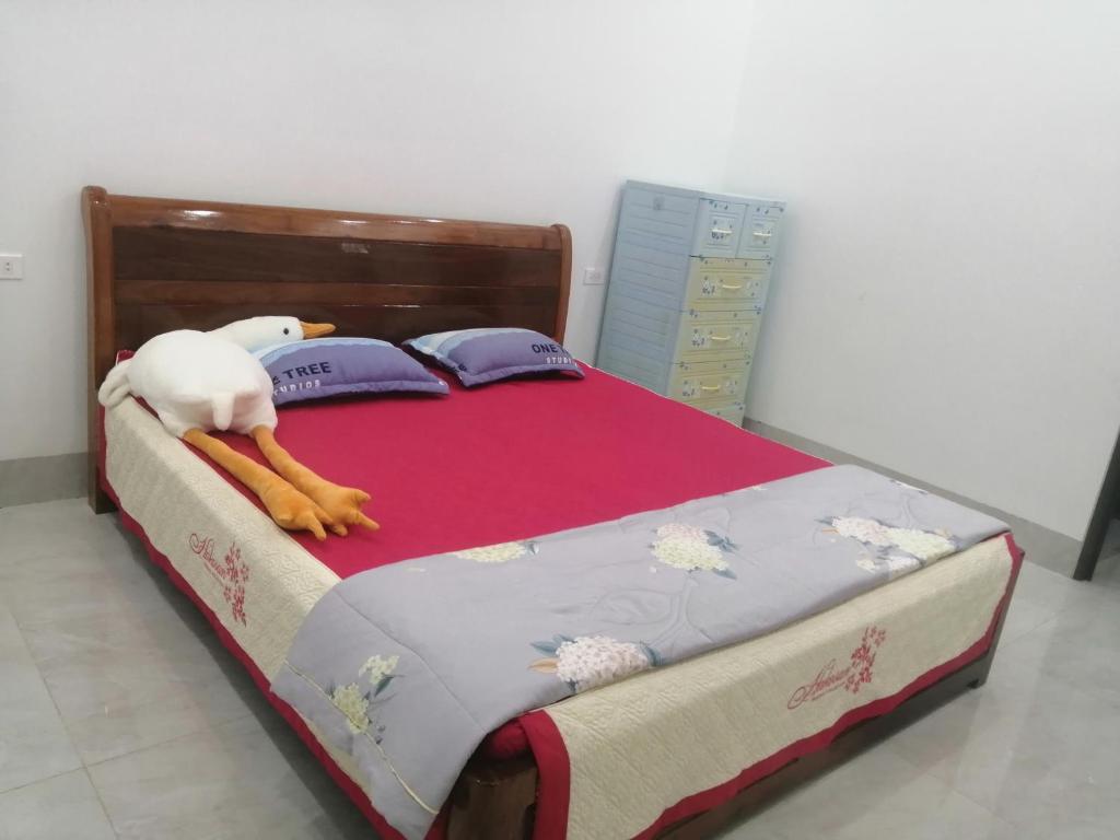 a bed with a stuffed animal laying on it at Phòng nghỉ nhà Thiên Lý in Dien Bien Phu