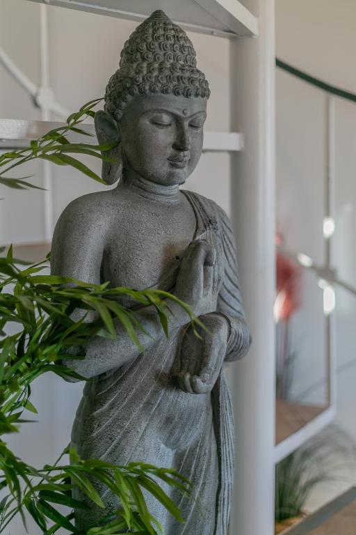 a statue of a buddha standing next to a plant at DUPLEX TEMPLO NEVADO con 2 Parking cubiertos gratis in Sierra Nevada