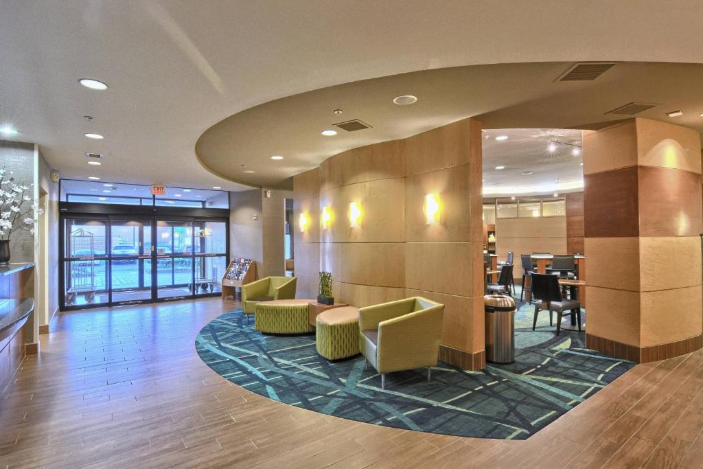 a lobby with a waiting area with chairs and tables at SpringHill Suites Detroit Southfield in Southfield