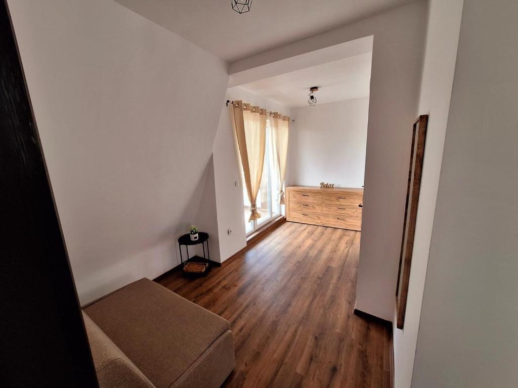 an empty living room with a couch and a window at Апартамент БОХО Приморско in Primorsko