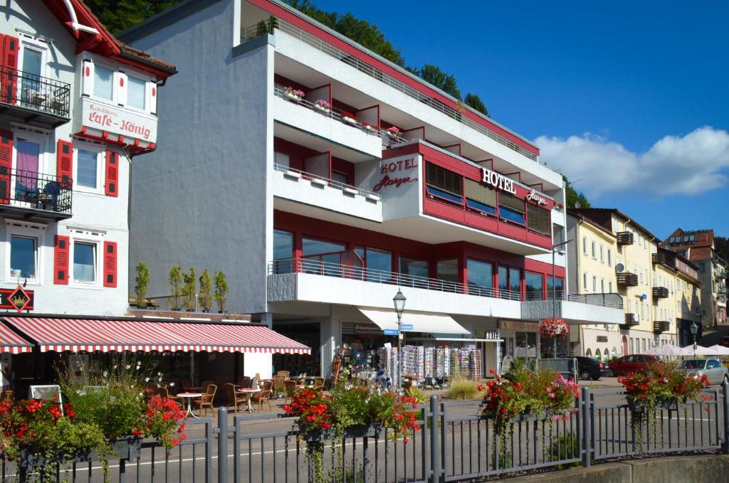 Hotel Harzer am Kurpark في باد هيرنالب: مبنى ابيض بالورود امامه