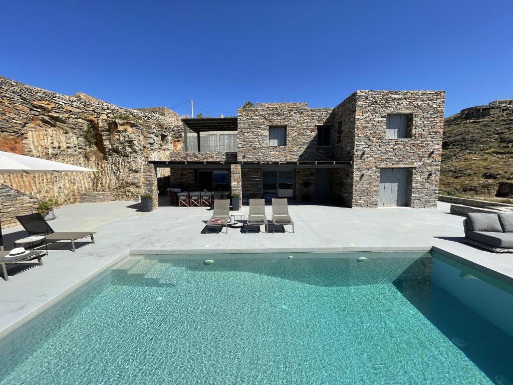 - une piscine en face d'une maison en pierre dans l'établissement VeneTerra - Refined Elegance in a 4-Bed Kea Villa, à Koundouros
