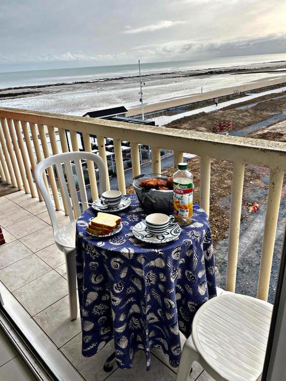 - une table avec un bol de nourriture sur le balcon donnant sur la plage dans l'établissement STUDIO DDAY, à Langrune-sur-Mer