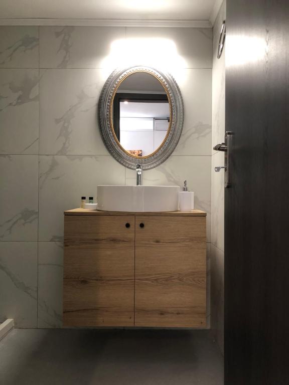 a bathroom with a sink and a mirror on the wall at Chrysa- Kyra Apartments in Heraklio Town