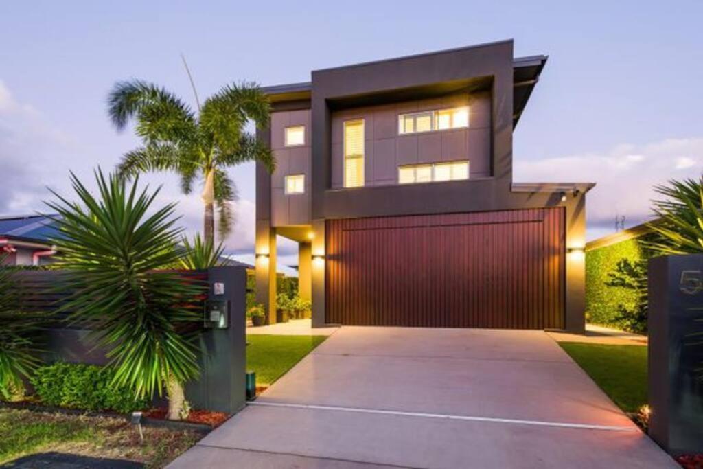 a modern house with a red garage at Hope Island Little Paradise in Gold Coast