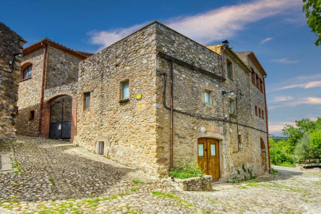 un antiguo edificio de piedra con puerta de madera en Can Parralets, en Camallera
