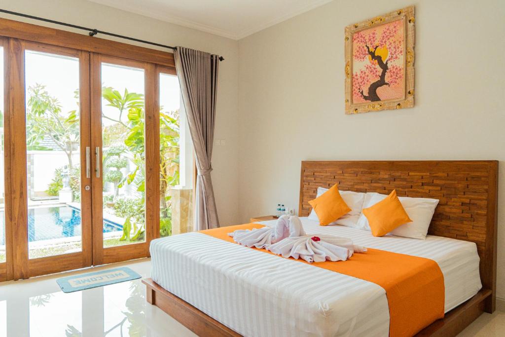 ein Schlafzimmer mit einem Bett und einem großen Fenster in der Unterkunft Villa Nugraha Lovina Private Pool in Singaraja