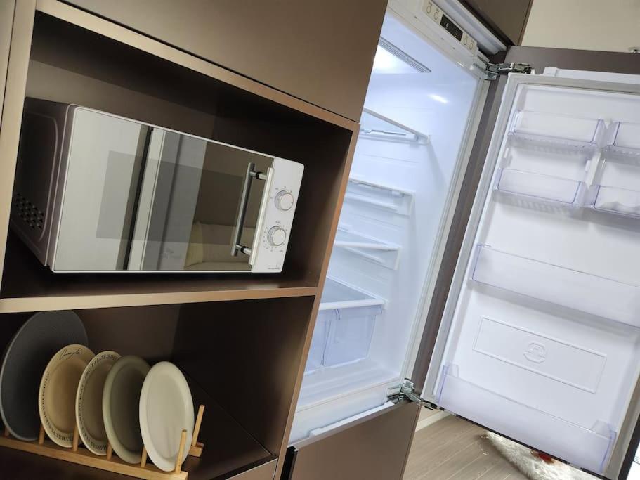 a refrigerator with its door open and a microwave at Stay Marina Ocean in Ansan