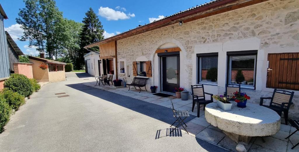 a patio with chairs and a table in front of a building at La Forge du Rosay in Viry