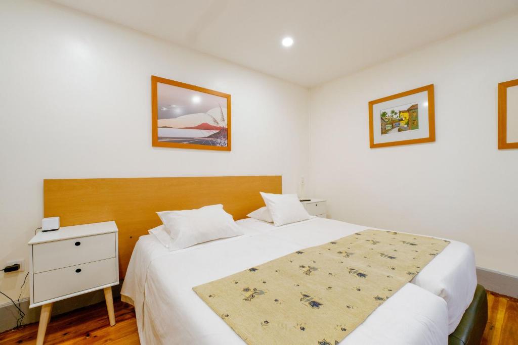 ein Schlafzimmer mit einem großen Bett und einem Nachttisch mit einem Bett der Marke sidx sidx sidx. in der Unterkunft À Francos Painting Artist 2 in Porto