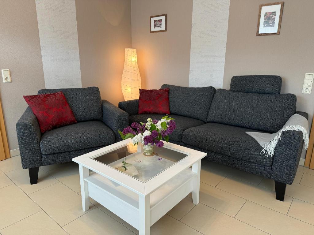 Sala de estar con 2 sofás y mesa de centro en Großzügige Wohnung mit Schreibtischarbeitsplatz in Genthin OT Tucheim, en Tucheim