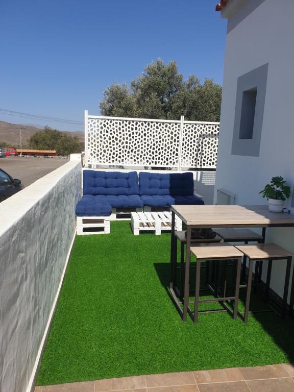 a patio with a couch and a table and grass at Acogedora casita in El Charco