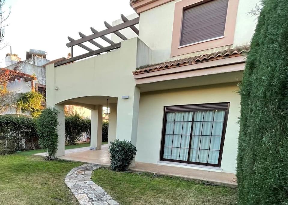 Casa blanca con ventana y patio en Casa en Ruta de la Plata con piscina comunitaria, en Guillena